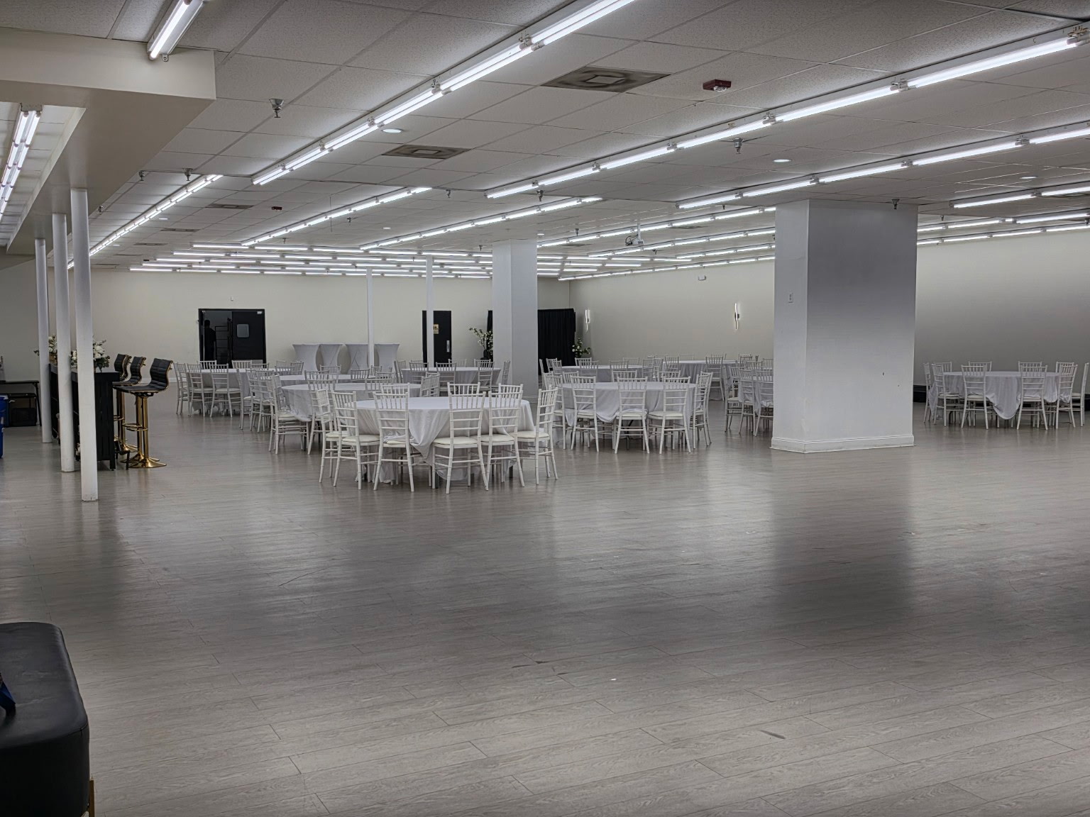 Celebration Hall spacious event room with white tables and Chiavari chairs
